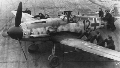 Vokiečių aerodromo aptarnaujantis techninis personalas apsuka „Messerschmitt Bf-109 G“.
