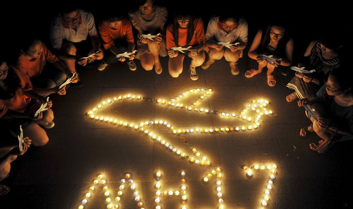 MH17 tragedijos vietoje žmonės neša vainikus ir stato kryžius