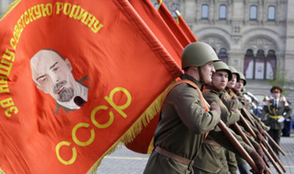 Parade dalyvaujantys kariai nešasi vėliavas su Vladimiro Lenino atvaizdu