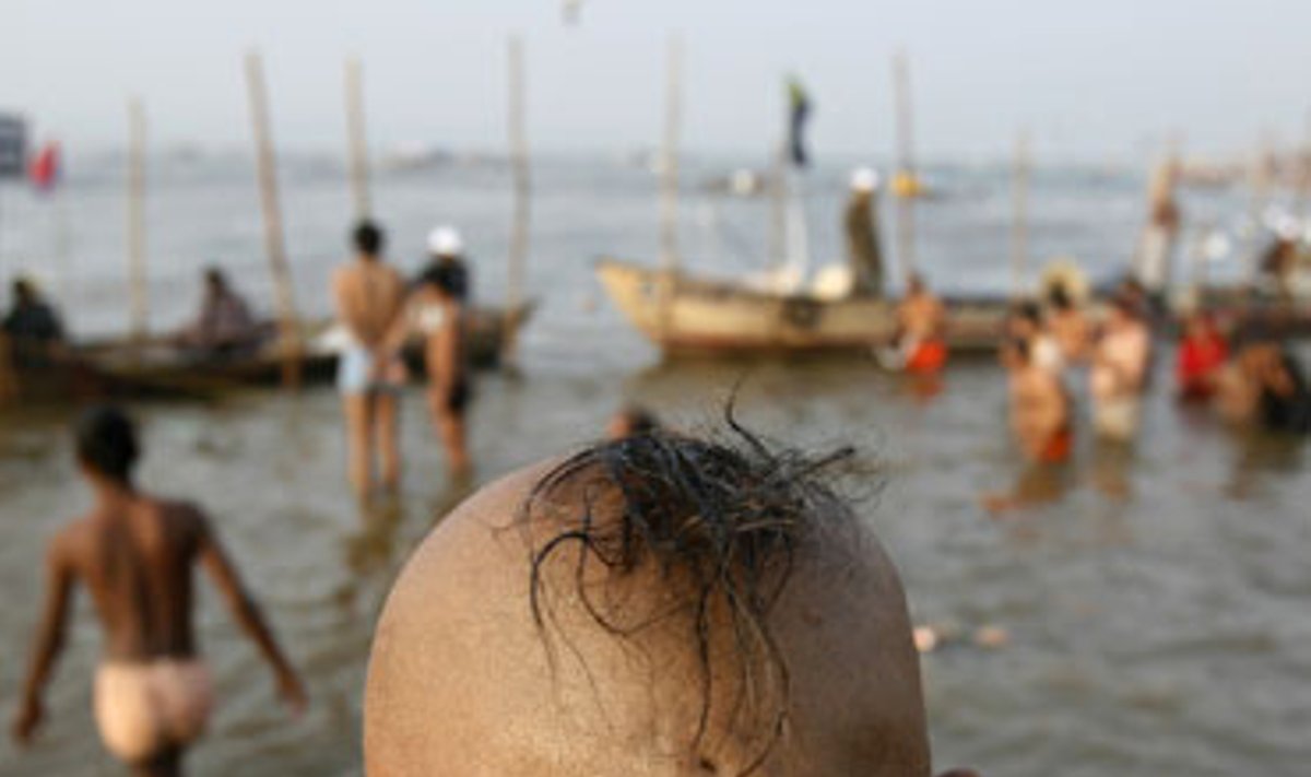 Induistas ruošiasi pasinerti į šventąją Gango upę.