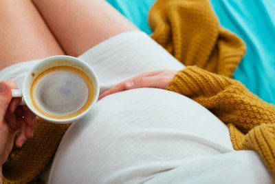 Nėščia moteris geria kavą
