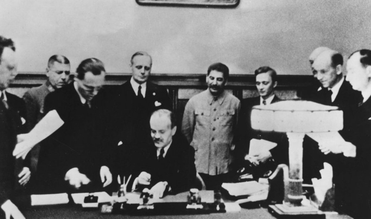 Molotovo-Ribbentropo pakto pasirašymas 1939 m. rugpjūčio 23 d. Prie stalo sėdi Viačeslavas Molotovas, už jo stovi Joachimas von Ribbentropas ir Josifas Stalinas. 