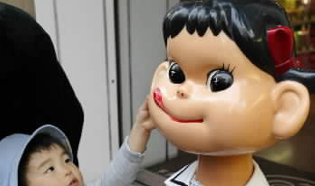 Japanų berniukas bando paliesti apvaliažandę lėlę Tokijuje esančioje “Fujiya Co Ltd” parduotuvėje. 