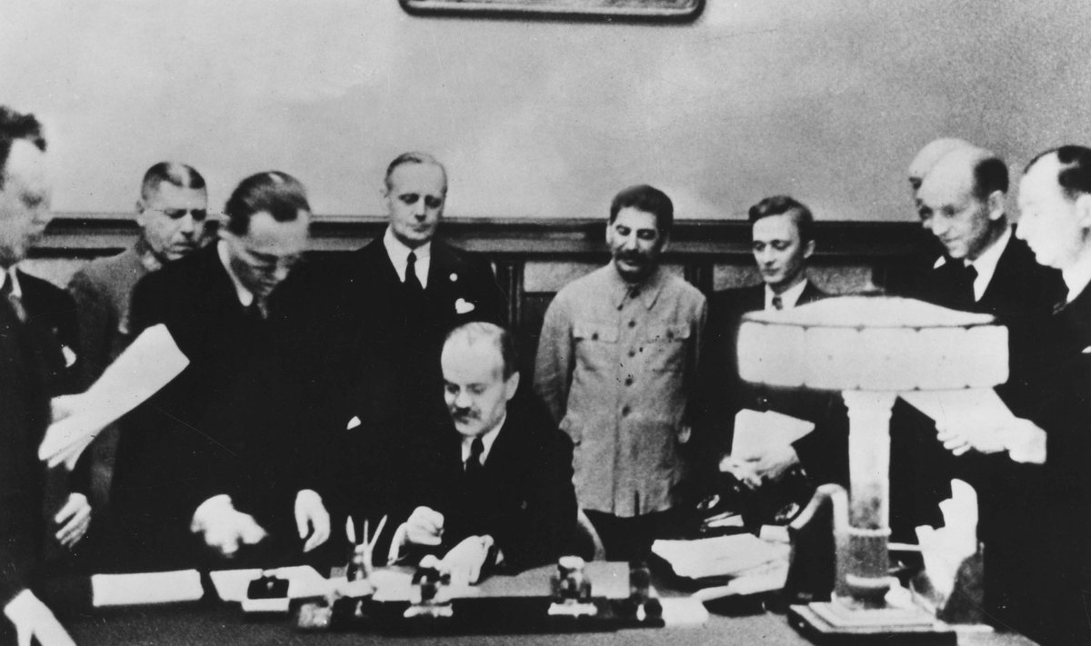 Molotovo-Ribbentropo pakto pasirašymas 1939 m. rugpjūčio 23 d. Prie stalo sėdi Viačeslavas Molotovas, už jo stovi Joachimas von Ribbentropas ir Josifas Stalinas. 