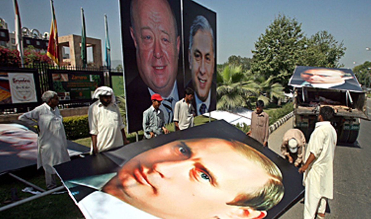 Pakistane laukiant Rusijos premjero vizito darbininkai kabina plakatą su V.Putino atvaizdu. 