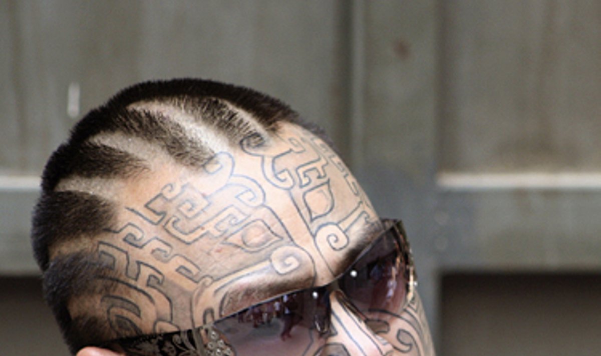 Kinijoje vykstančiame tatuiruočių šou vyras demonstruoja tatuiruotėmis išpieštą veidą. 