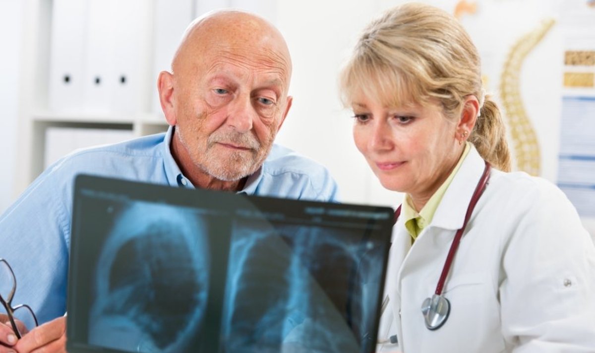 Pacientas ir gydytoja žiūri rentgeno nuotrauką