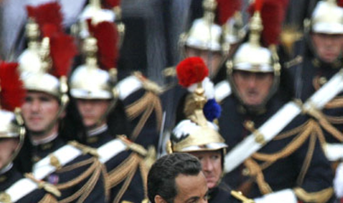 Prancūzijos prezidentas Nicolas Sarkozy mojuoja miniai, važiuodamas Eliziejaus laukais.