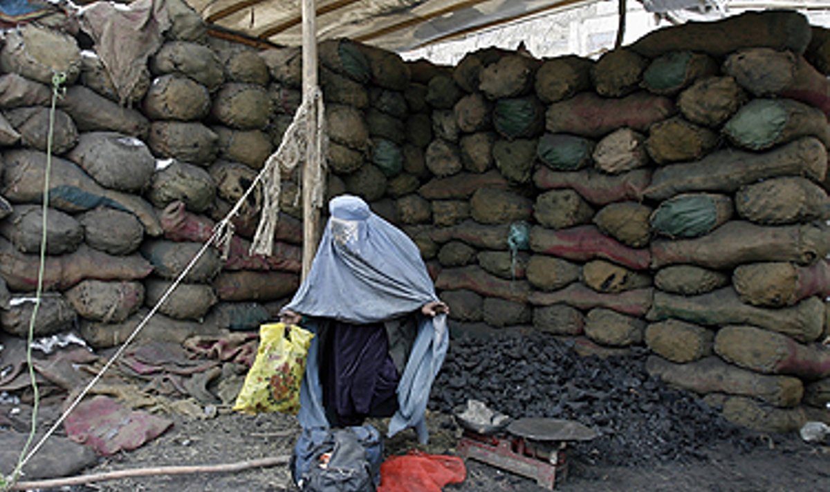 Afganistanietė neša krepšius su anglimi, kurią naudos maisto gaminimui namuose. 