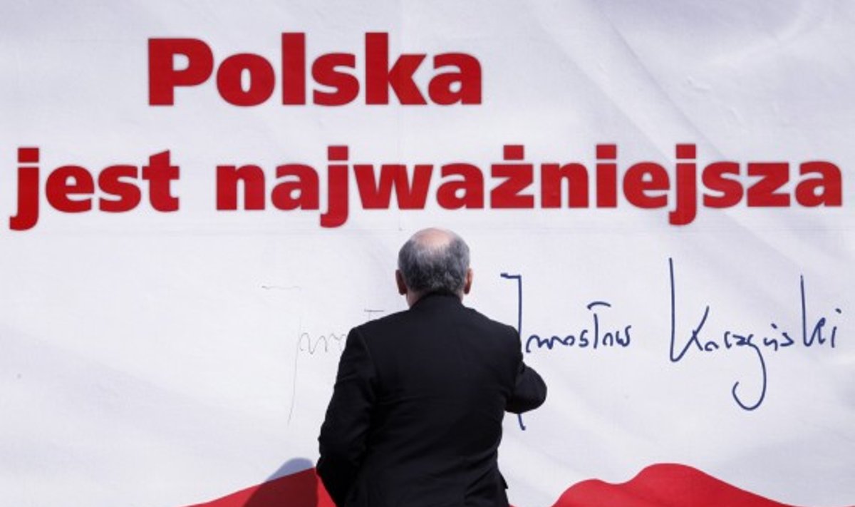 Lenkijos politikas Jaroslawas Kaczynskis pasirašo ant savo rinkiminio plakato