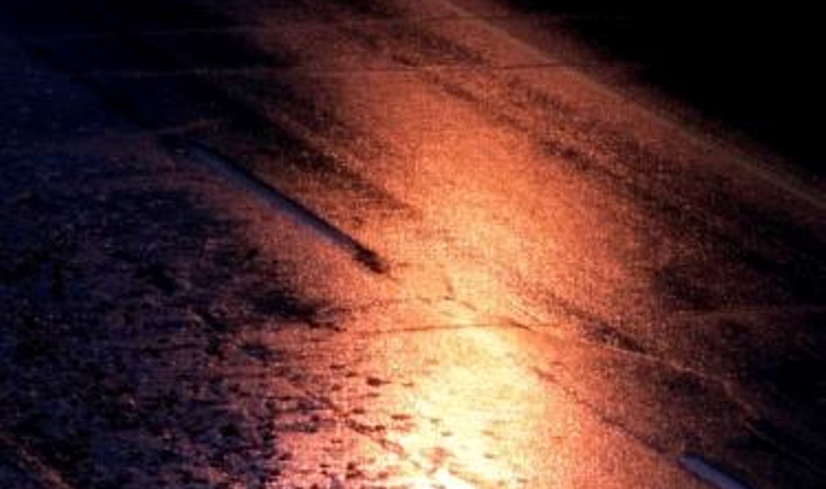 Pėsčiasis lietuje, apšviestas Otavos gatvės lempų