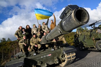 Ukrainiečių kariai su civiliais ant britų tanko