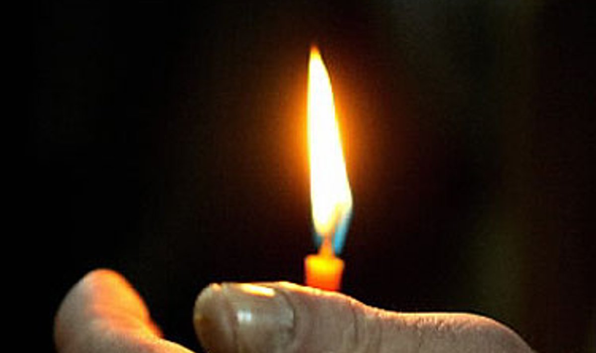 Vyras laiko žvakę cerkvėje per stačiatikių Kalėdas