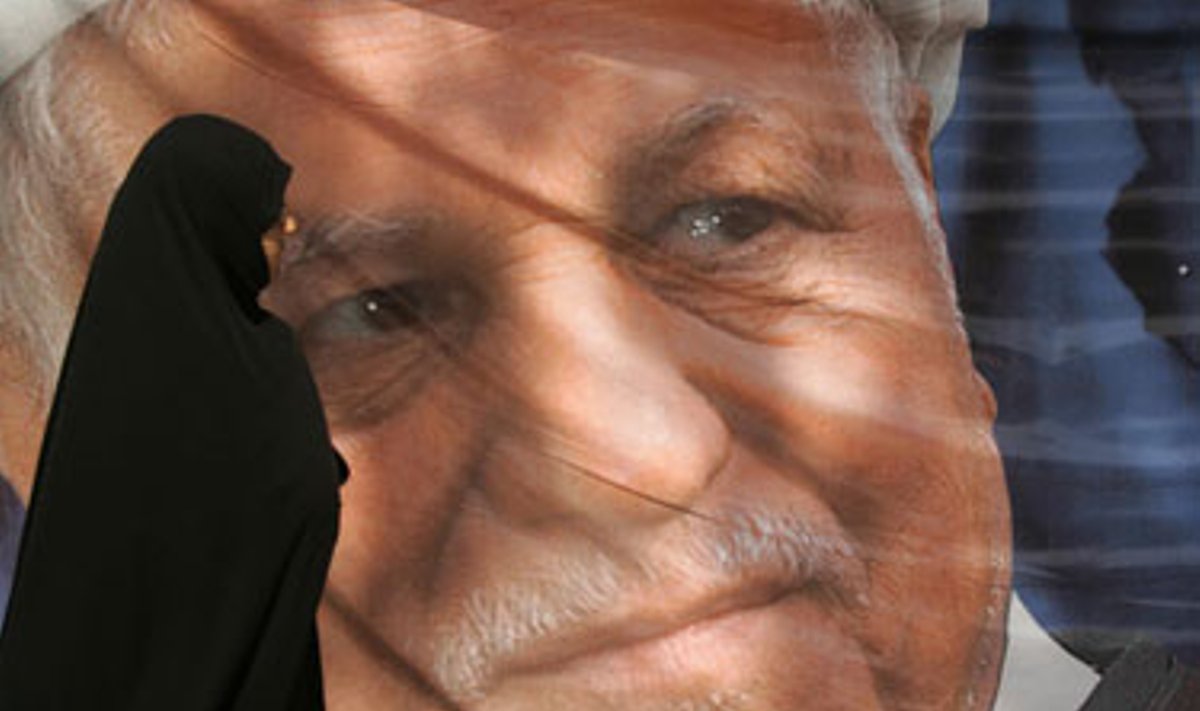 Iranietė moteris eina pro kandidato į prezidentus Akbar Hashemi Rafsanjani reklaminį plakatą Teherane. 