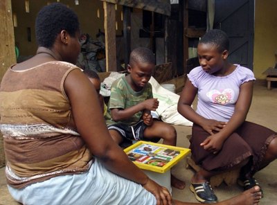 Cape Coast (Gana) stalo žaidimą žaidžianti moteris ir vaikai 
