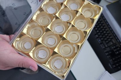 Tiesiai virš mokslininko nykščio galime įžiūrėti mažytę „dėmelę“ – ant jos telpa 15 kvantinių supergardelių.