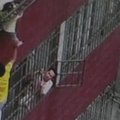 Kinijoje mažas vaikas pakibo už galvos 4 aukšto balkone