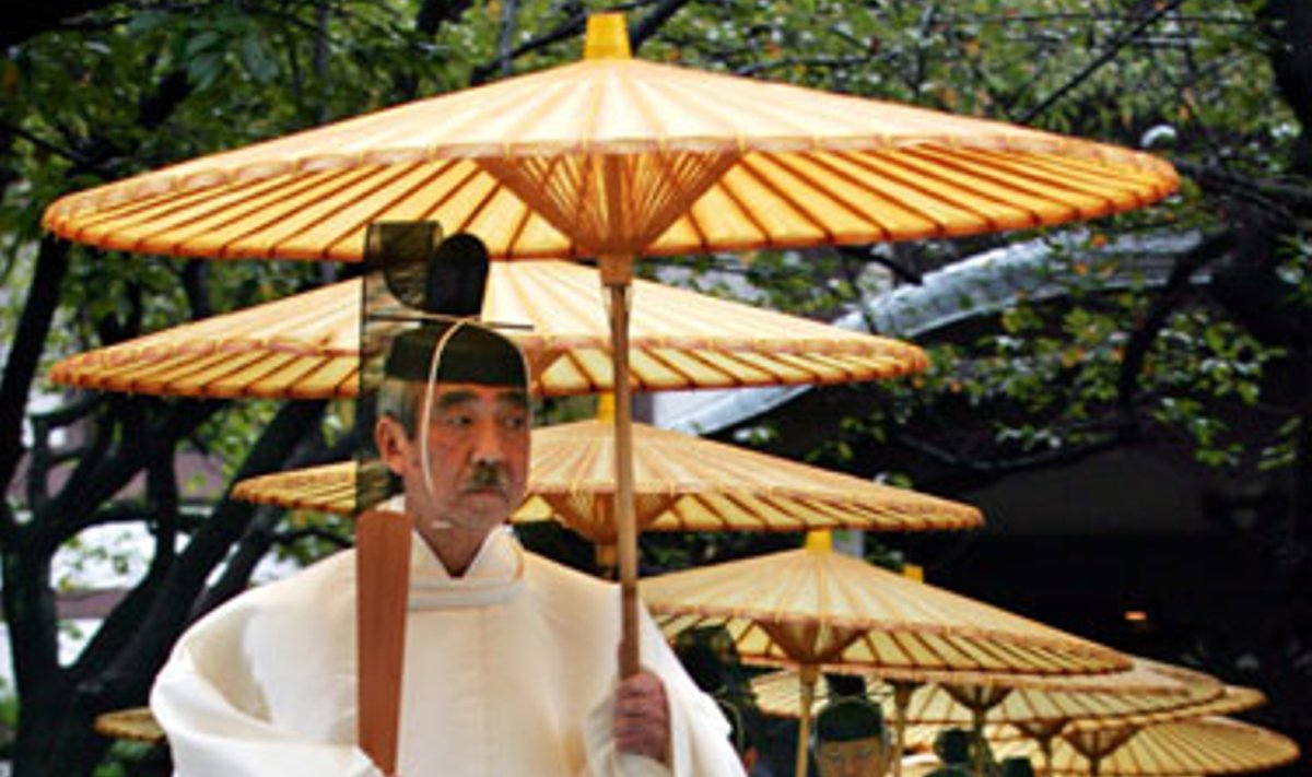 Japonų Šinto dvasininkai laikydami popierinius skėčius eina per lietų rudens festivalyje Tokijuje. 