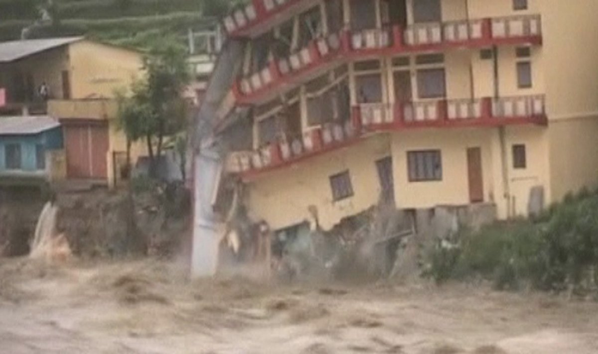 Liudininkai Indijoje užfiksavo, kaip potvynio vandenys nugriauna namą