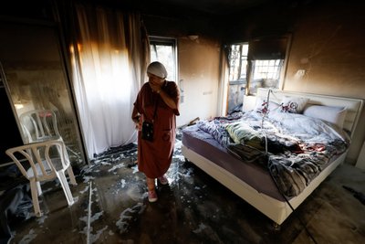 A woman stands in a damaged room after rockets were launched from the Gaza Strip, in Ashkelon, Israel October 7, 2023. REUTERS/Amir Cohen