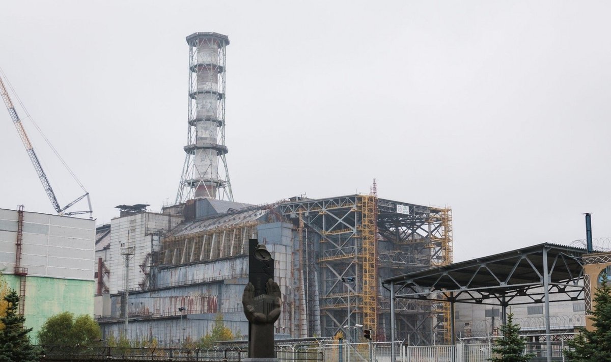 Černobylio AE ketvirtojo bloko sarkofagas ir kombinuotoji stabilizuojanti plieno konstrukcija. Priešais monumentas didvyriams – profesionalams, likvidavusiems katastrofos padarinius. Andrew Leatherbarrow nuotrauka.