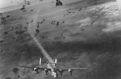 Bombonešis B-24 išnyra iš Flakų sviedinių sprogimų debesies su pažeistu varikliu