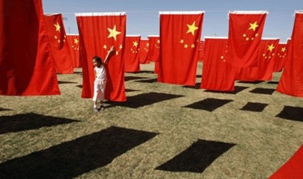 Maža mergaitė žaidžia su Kinijos vėliavomis Pekino parke
