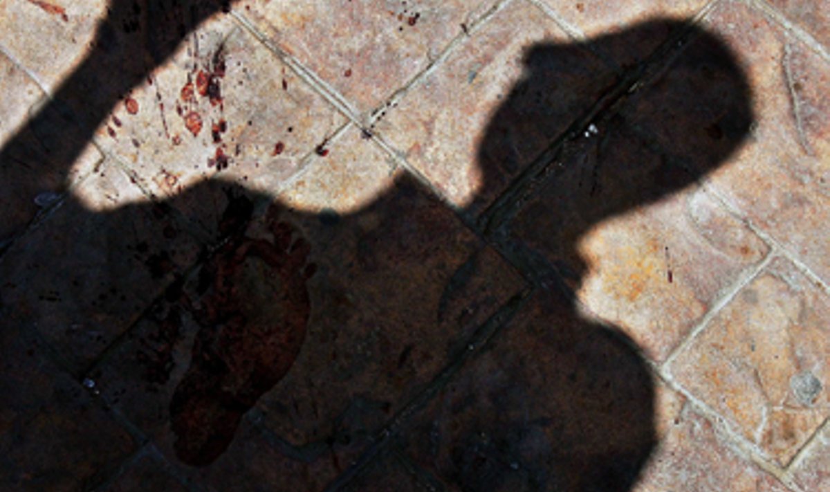 Po sprogimų krauju aptaškytame Dahabo miesto grindyje matomas praeinančio turisto šešėlis. 