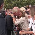 Moteris pabučiavo į skruostą minią sveikinusį Karolį III
