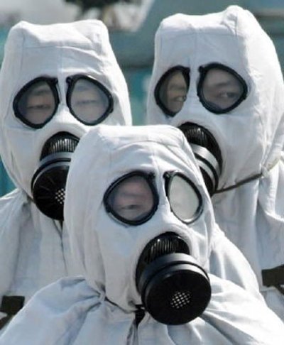 Japonų policija, vilkinti nuo chemikalų apsaugančią aprangą, treniruojasi kaip elgtis cheminio teroro atveju.