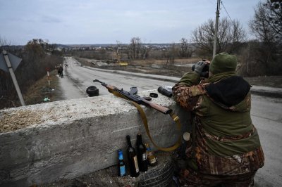 Ukrainos karys pro žiūronus žiūri į Stojankos miestelį, esantį netoli Kijevo