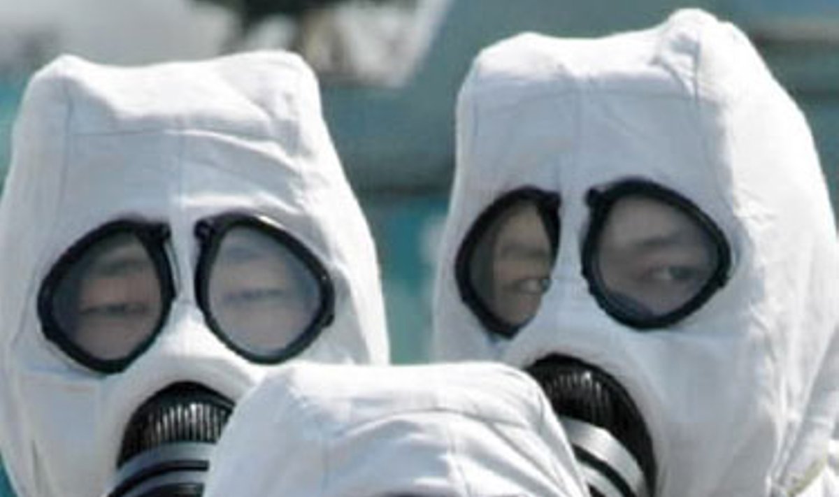Japonų policija, vilkinti nuo chemikalų apsaugančią aprangą, treniruojasi kaip elgtis cheminio teroro atveju.