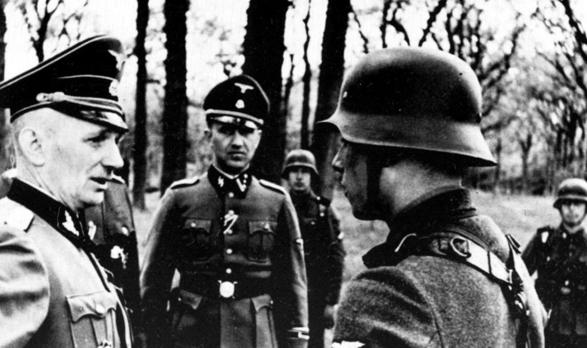 SS oberfiureris A. Borchertas kalbasi su Latvių legiono puskarininkiu. Latvių legionieriai nelaikyti tikraisiais SS nariais, nors daugelis mano priešingai.
