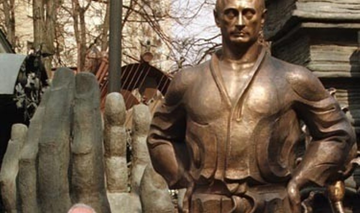 Rusų skulptorius Zurabas Cereteli pozuoja greta bronzinės Rusijos prezidento Vladimiro Putino statulos. 