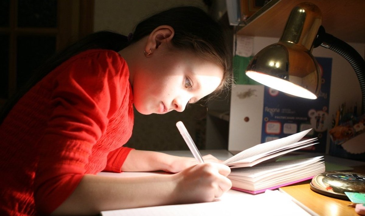 Mergaitė ruošia namų darbus