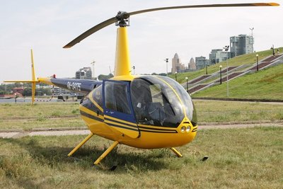 Частный четырехместный вертолет Robinson R44 на траве в Казани