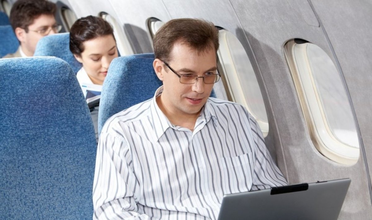 Vyras naudojasi kompiuteriu skrydžio metu