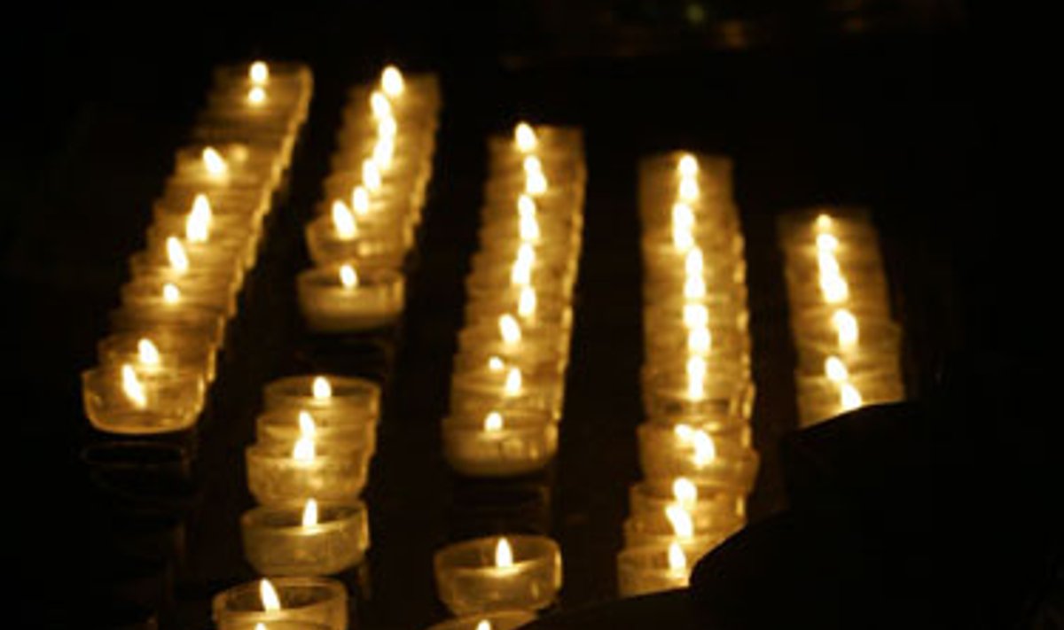 Moteris degina žvakutę per vidudienio mišias Kelno Katedroje.  