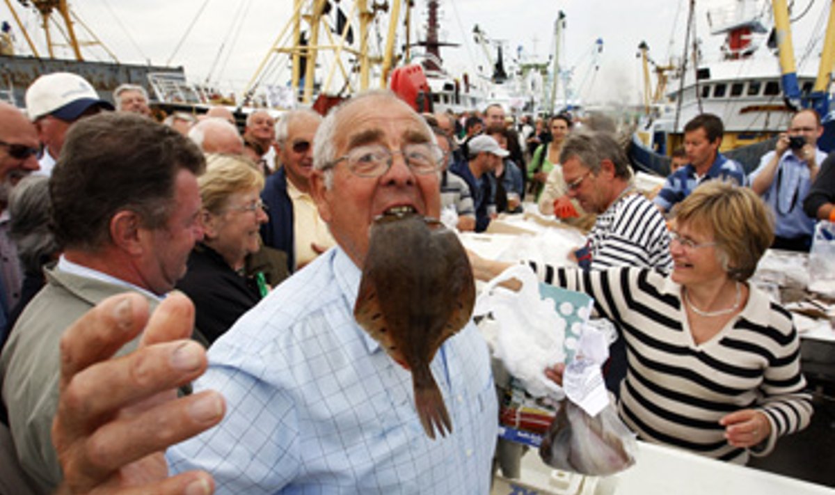 Plekšnę įsikandęs vyras laukia nemokamos žuvies Zeebrugge uoste. Belgijos žvejai išdalino toną plekšnių, protestuodami prieš Europos Komisijos žvejybos kvotas, brangstančius degalus ir žemas žuvų kainas.