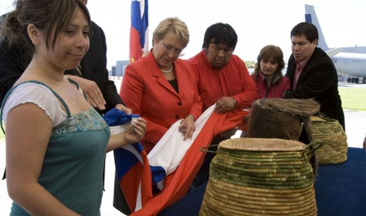 Čilės prezidentė M. Bachelet pagerbimo ir atsiprašymo ceremonijoje grąžina  alakalufų/ kaveskarų genties  indėnų  palaikus jų giminaičiams.