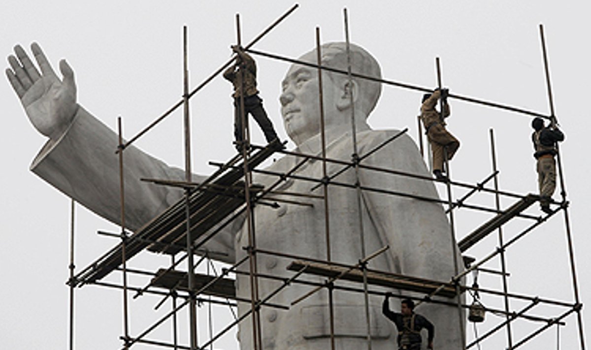 Darbininkai tvirtina metalines konstrukcijos šalia Kinijos lyderio Mao Dzeduno skulptūros, kad galėtų ją nuvalyti. 