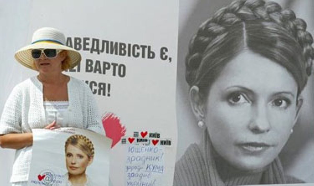 Moteris laiko Juliją Timošenko palaikantį plakatą Kijeve. 