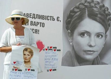 Moteris laiko Juliją Timošenko palaikantį plakatą Kijeve. 