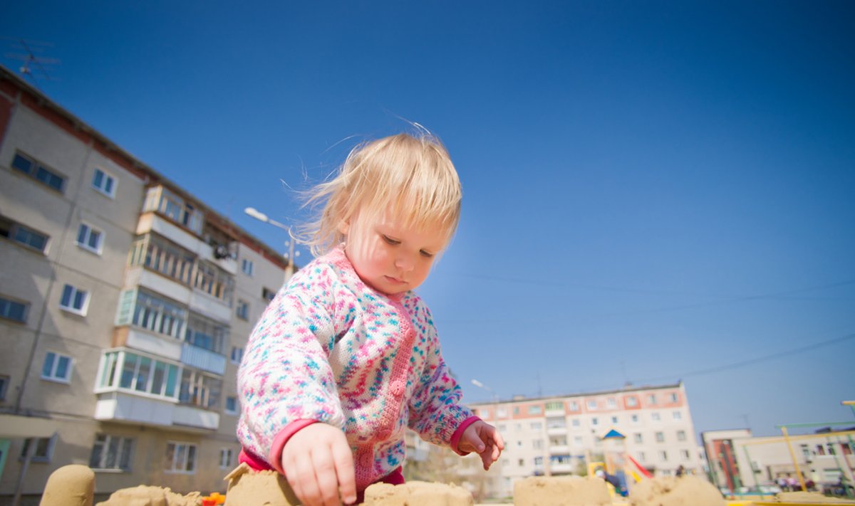 Mergaitė žaidžia smėlio dėžėje