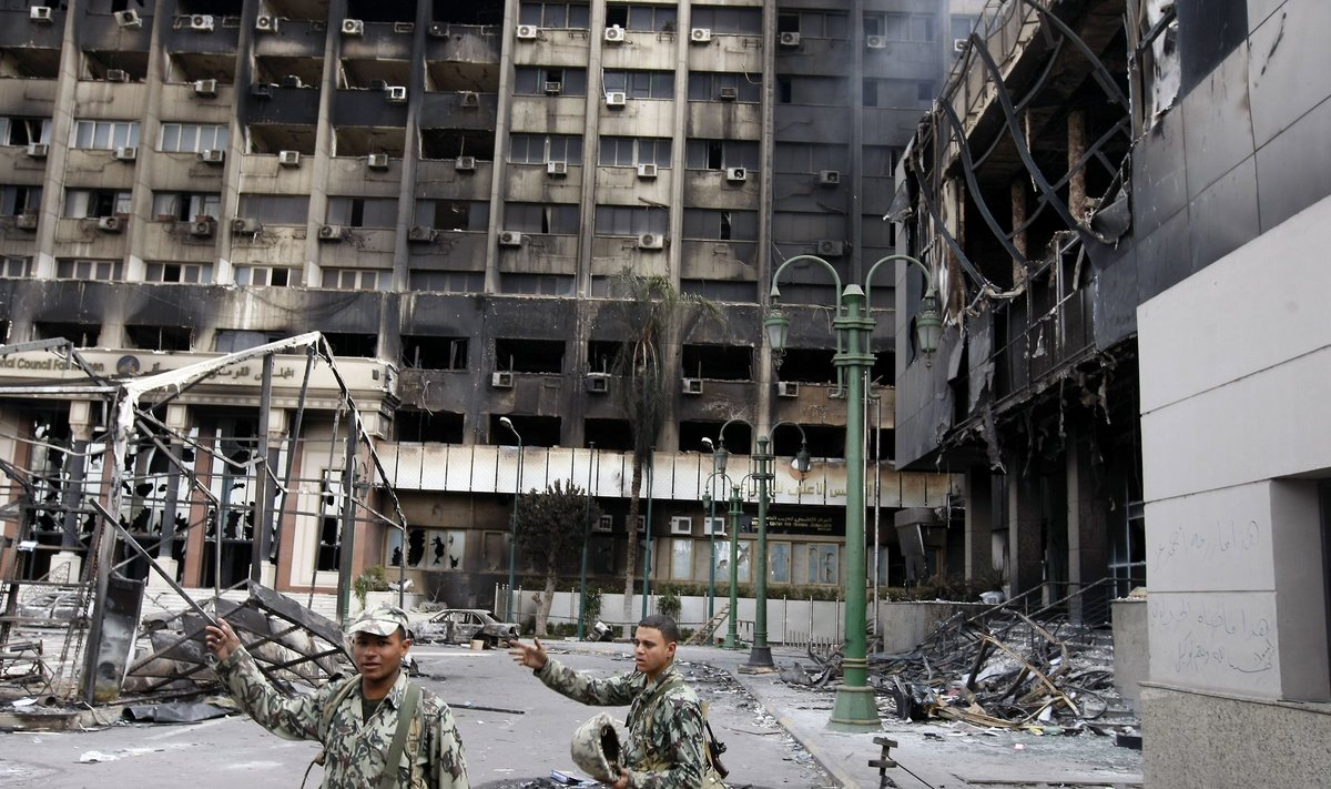 Egipto kariai prie gaisro suniokoto pastato Kairo centre