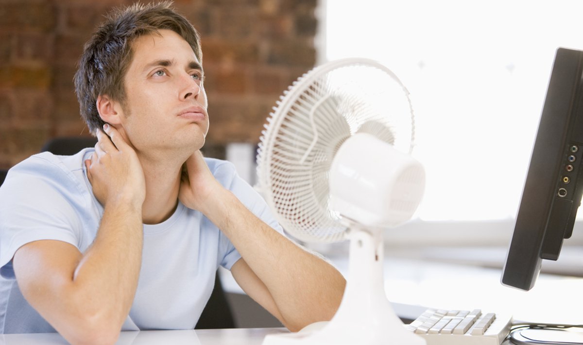 Biure karšta, ventiliatorius, nuo karščio kenčiantis darbuotojas