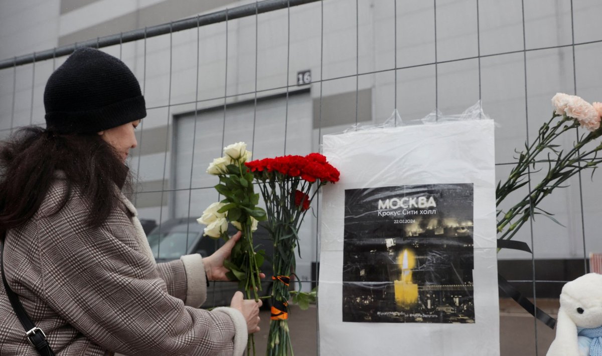A woman places flowers at a makeshift memorial to the victims of a shooting attack at the Crocus City Hall concert venue in the Moscow Region, Russia, March 23, 2024. REUTERS/Yulia Morozova
