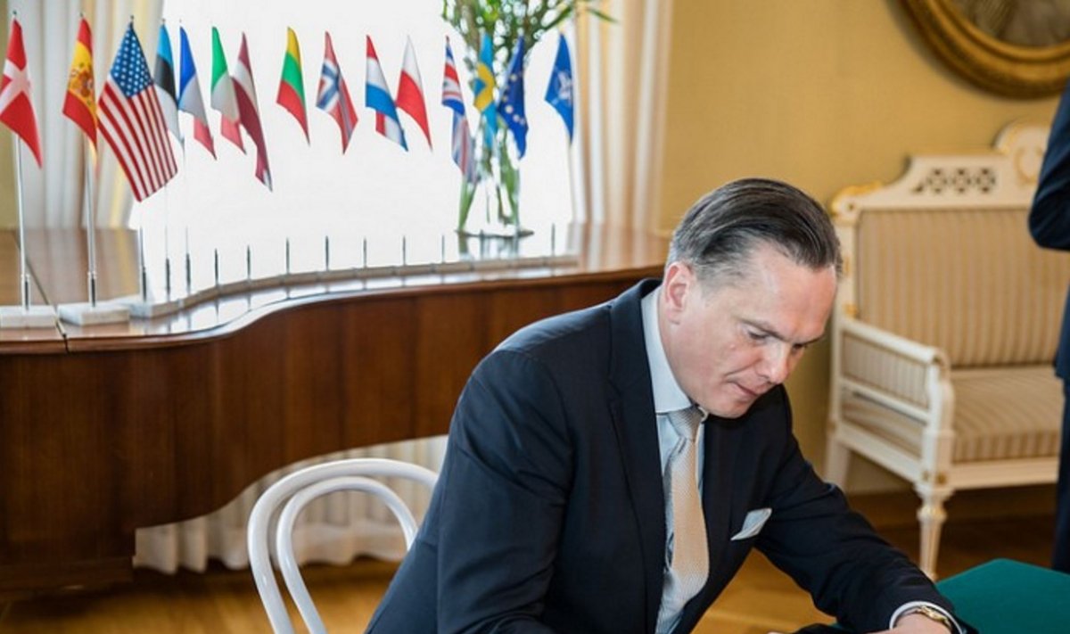 Ambassador at Large, H.E. Eitvidas Bajarūnas signs the document in Helsinki