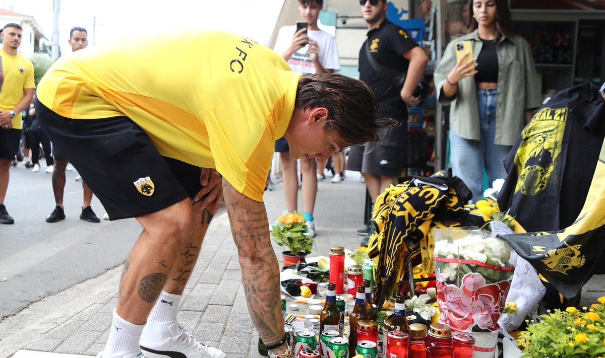 AEK žaidėjas deda gėles vietoje, kurioje mirtinai buvo sužeistas AEK klubo sirgalius