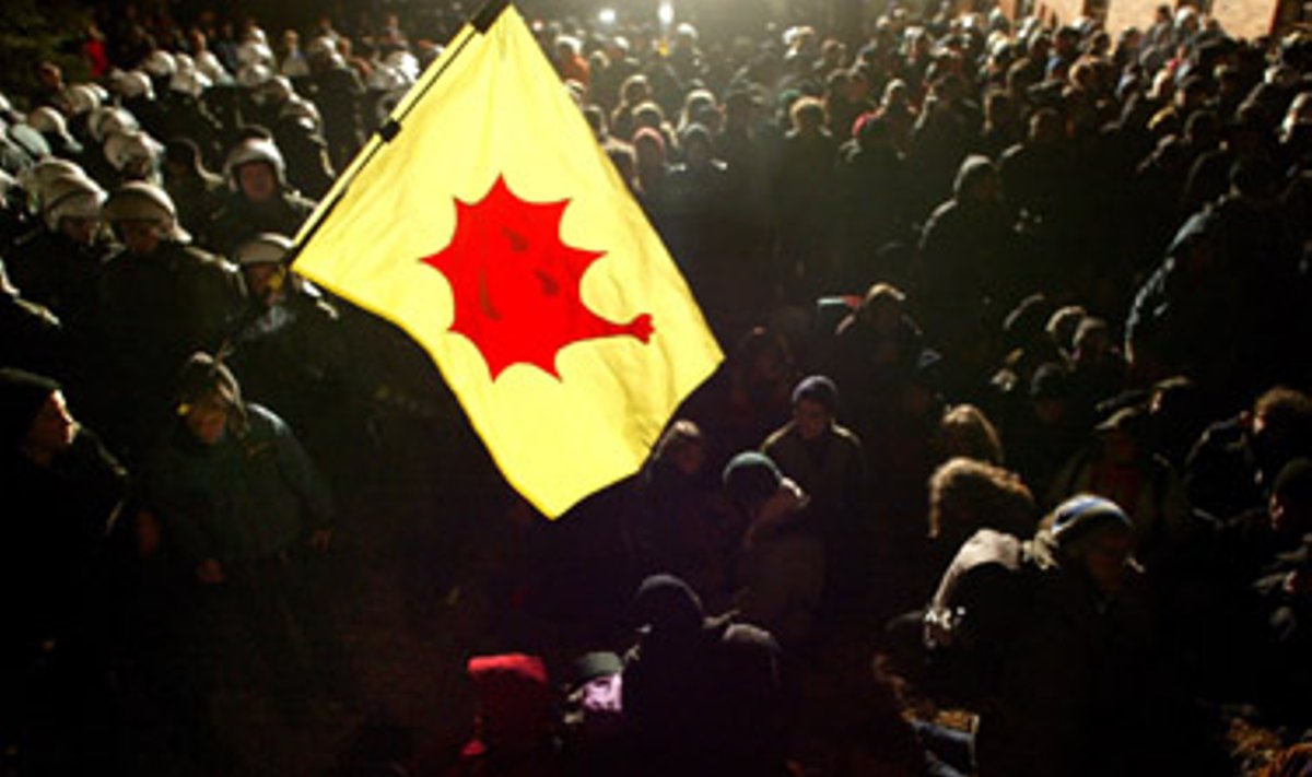 Protestuotojų laikomoje vėliavoje – antibranduolinės kampanijos simbolis. Įvairiuose Vokietijos miestuose pastaruoju metu tūkstančiai žmonių protestuoja prieš branduolinių atliekų pervežimą.